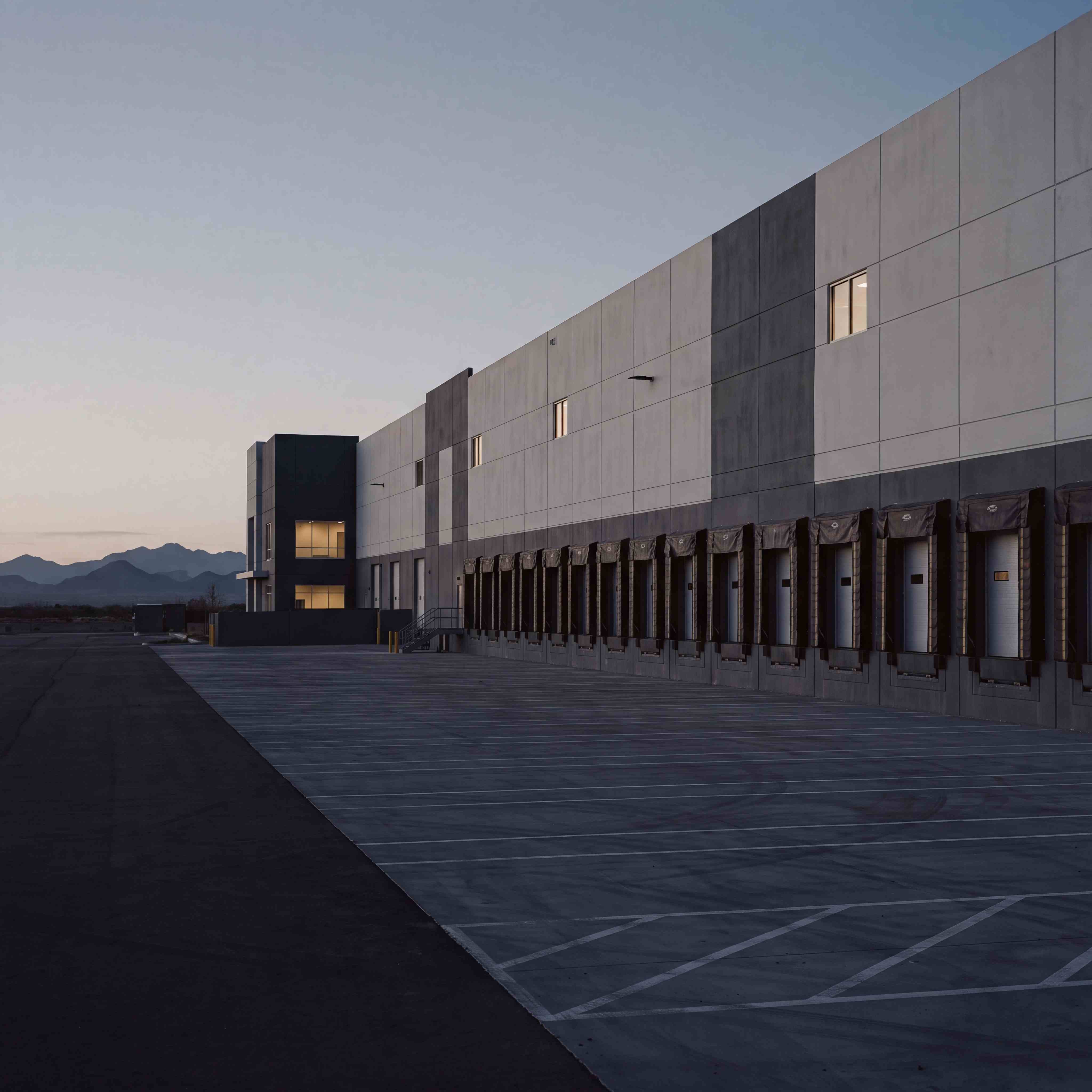 Loading dock bays at a modern industrial distribution warehouse at dusk